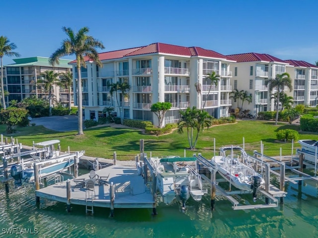 view of dock with a yard and a water view