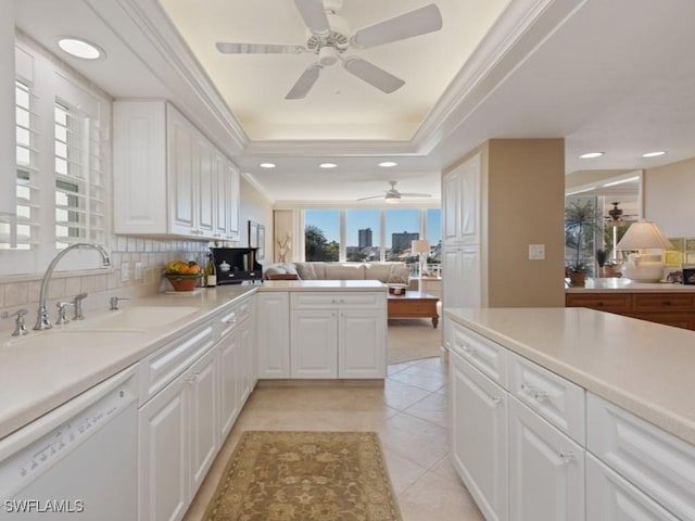 kitchen featuring sink, light tile patterned flooring, kitchen peninsula, white dishwasher, and white cabinets