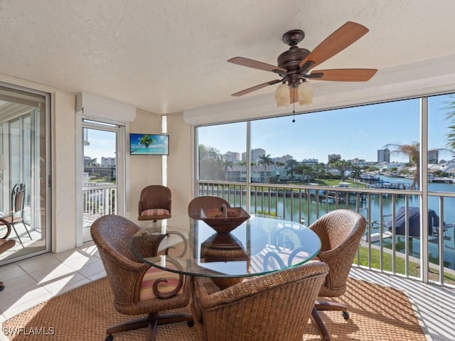 sunroom / solarium with a water view and ceiling fan