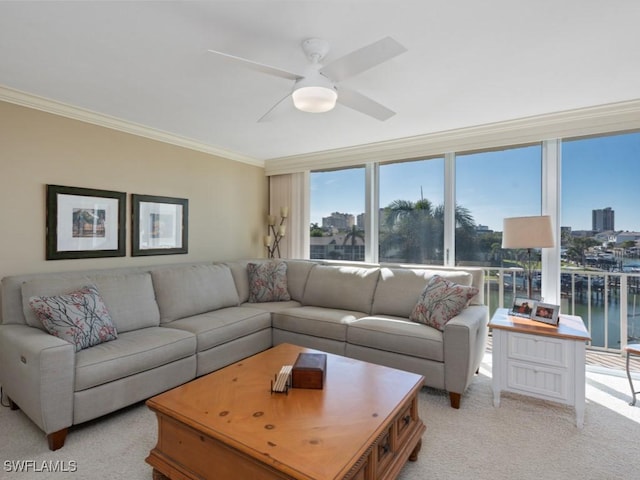 living room with light colored carpet, ceiling fan, crown molding, and a water view