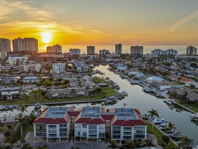 aerial view at dusk featuring a water view