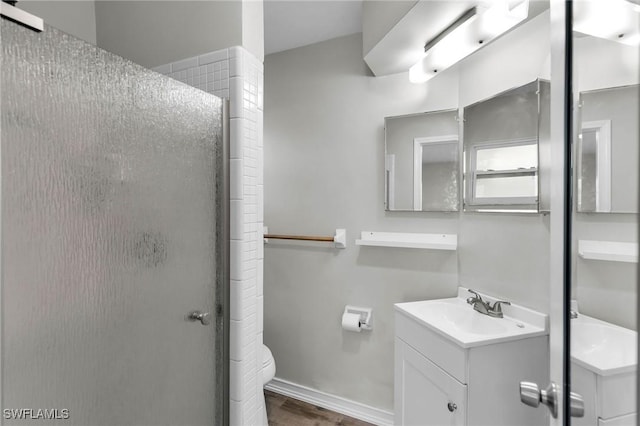 bathroom featuring vanity, toilet, and a shower with shower door