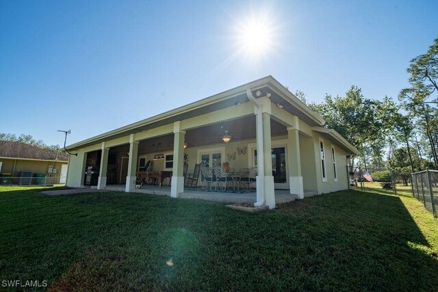 back of house with ceiling fan, a yard, and a patio