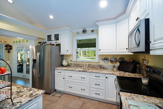 kitchen with appliances with stainless steel finishes, light stone countertops, and white cabinets