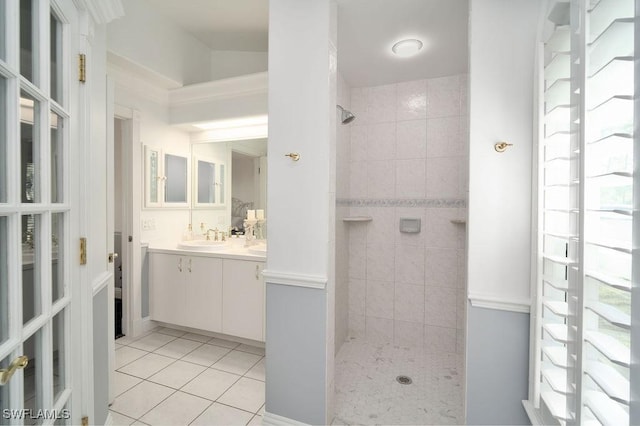 bathroom featuring tile patterned flooring, vanity, and tiled shower