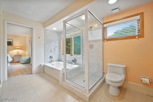 bathroom with tile patterned flooring, toilet, and plus walk in shower