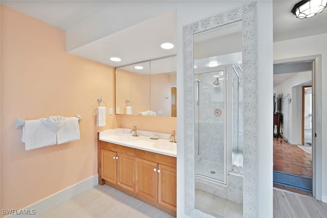 bathroom with a shower with door and vanity