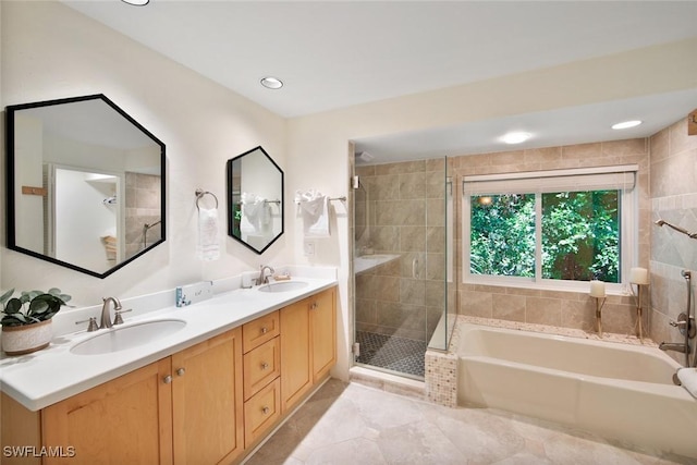 bathroom with tile patterned floors, vanity, and shower with separate bathtub