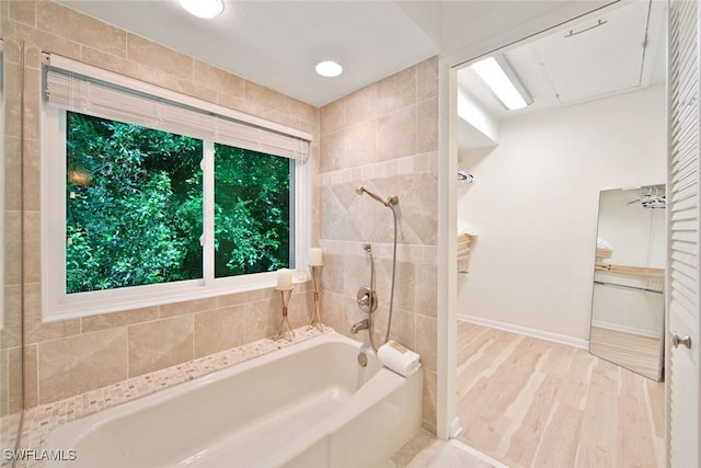 bathroom featuring tiled shower / bath combo and hardwood / wood-style flooring