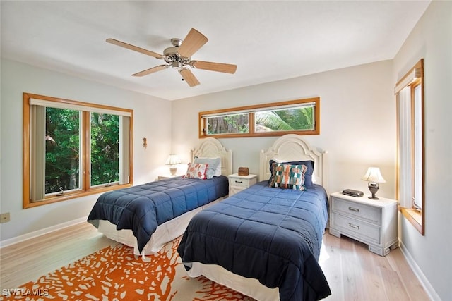 bedroom featuring multiple windows, ceiling fan, and light hardwood / wood-style flooring