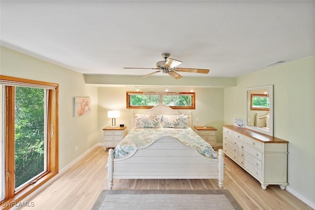 bedroom with ceiling fan, light hardwood / wood-style floors, and multiple windows