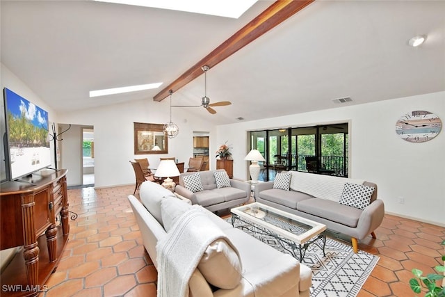 living room with lofted ceiling with skylight, ceiling fan, and light tile patterned floors