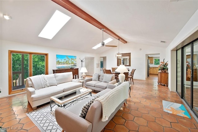 tiled living room with ceiling fan and lofted ceiling with skylight