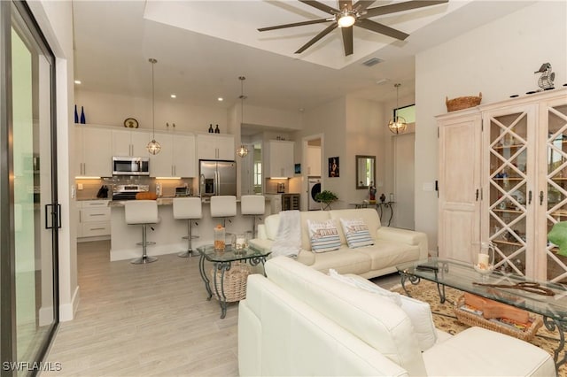 living room featuring ceiling fan and light hardwood / wood-style floors