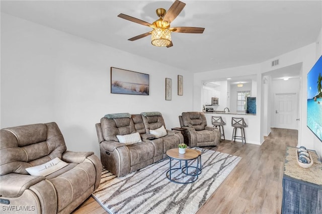 living room featuring ceiling fan and light wood-type flooring