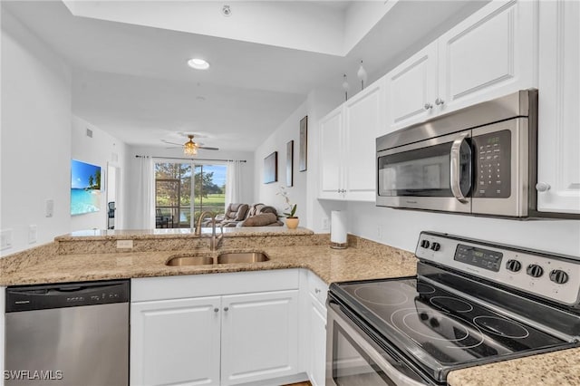 kitchen featuring kitchen peninsula, appliances with stainless steel finishes, white cabinets, and sink