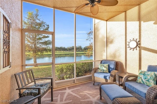 sunroom / solarium with ceiling fan, a water view, and a healthy amount of sunlight