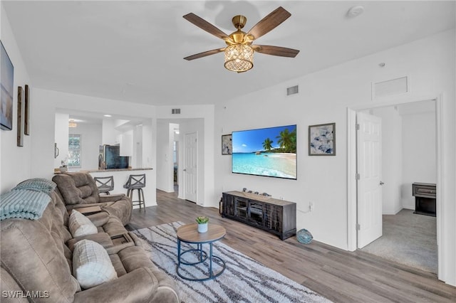 living room with ceiling fan and light hardwood / wood-style flooring