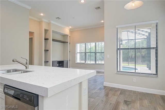 kitchen with stainless steel dishwasher, a healthy amount of sunlight, white cabinetry, and sink