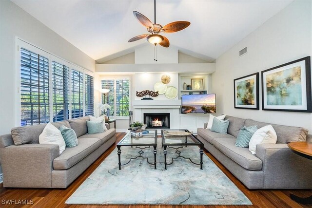 living room with ceiling fan, dark hardwood / wood-style flooring, and vaulted ceiling