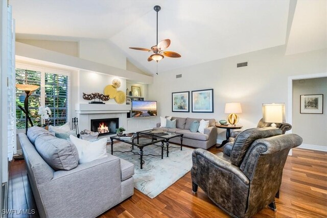 living room featuring hardwood / wood-style floors, ceiling fan, and vaulted ceiling