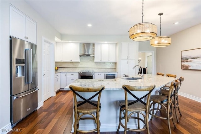 kitchen featuring white cabinetry, appliances with stainless steel finishes, sink, and wall chimney range hood