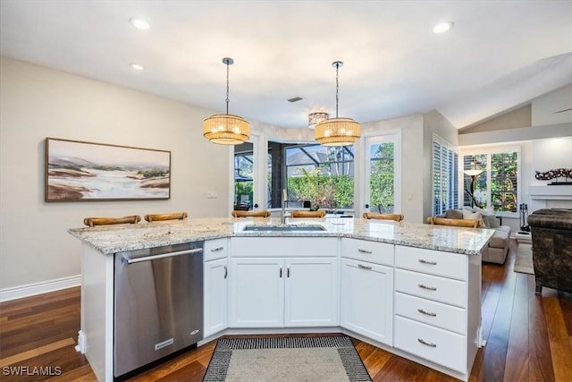 kitchen featuring dishwasher, dark wood-type flooring, sink, hanging light fixtures, and white cabinetry