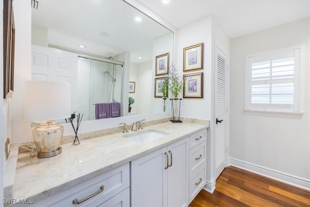 bathroom featuring vanity, wood-type flooring, and a shower with shower door