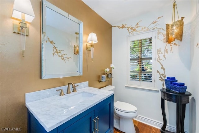 bathroom with hardwood / wood-style floors, vanity, and toilet