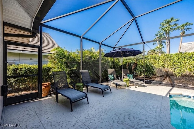 view of swimming pool with glass enclosure and a patio