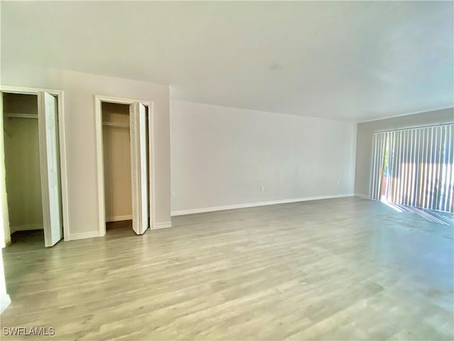 interior space with light wood-type flooring and multiple closets