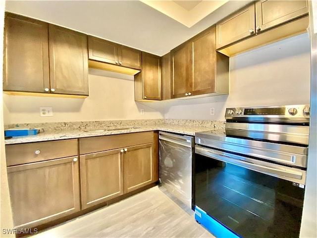 kitchen featuring light stone countertops and stainless steel range with electric cooktop