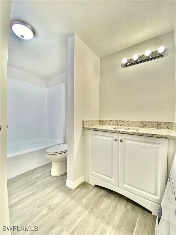 bathroom with hardwood / wood-style floors, vanity, and toilet