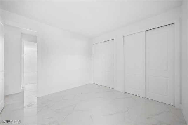 unfurnished bedroom featuring multiple closets