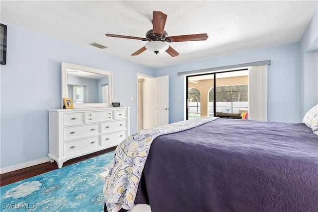 bedroom with ceiling fan, dark hardwood / wood-style flooring, a textured ceiling, and access to outside