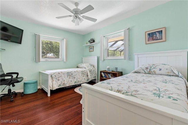 bedroom with multiple windows, ceiling fan, and dark hardwood / wood-style flooring