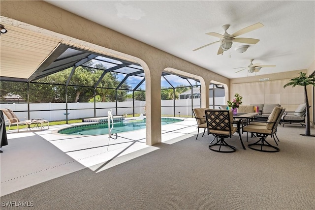 view of pool featuring pool water feature, glass enclosure, ceiling fan, and a patio