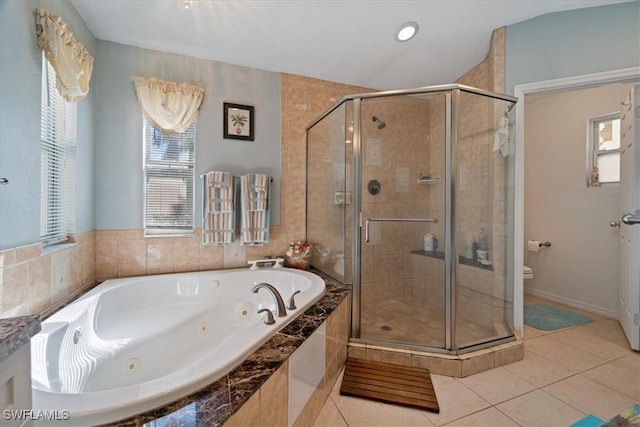 bathroom with toilet, tile patterned flooring, and shower with separate bathtub