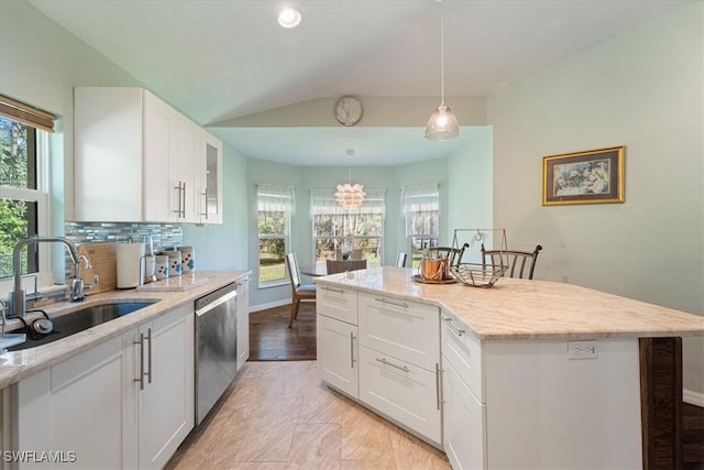 kitchen with white cabinets, a kitchen island, dishwasher, and sink