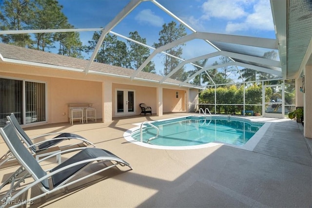 view of swimming pool with french doors, glass enclosure, and a patio area