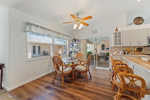 dining room with ceiling fan, dark hardwood / wood-style flooring, and lofted ceiling