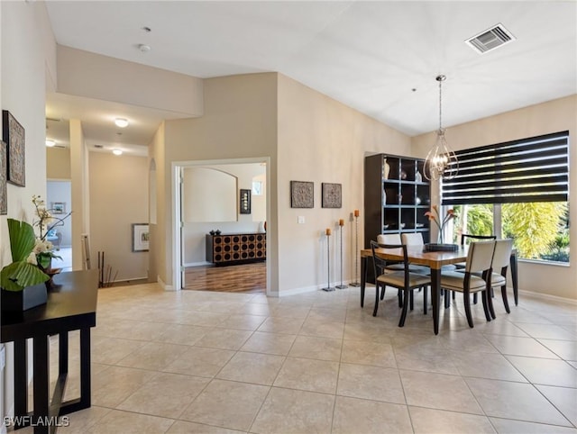 tiled dining room featuring a notable chandelier