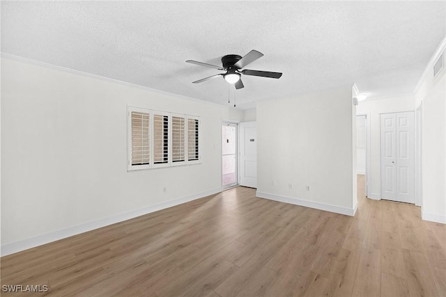 spare room featuring a textured ceiling, light hardwood / wood-style flooring, ceiling fan, and ornamental molding