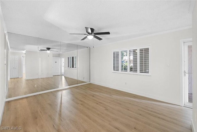 unfurnished bedroom featuring a textured ceiling, light wood-type flooring, and ceiling fan