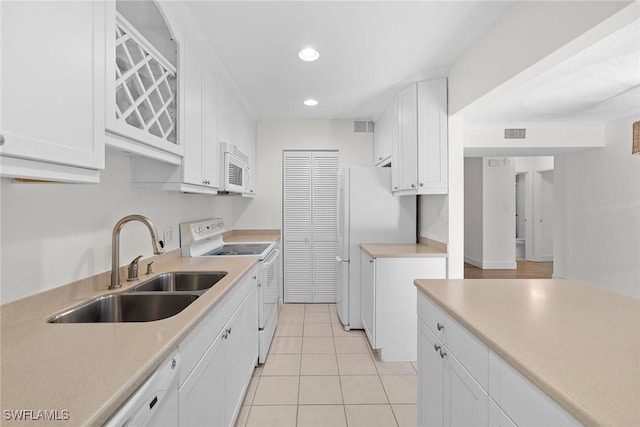 kitchen featuring white cabinetry, white appliances, sink, and light tile patterned floors