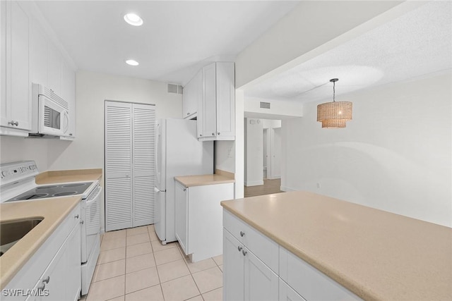 kitchen featuring light tile patterned floors, white cabinets, pendant lighting, and white appliances