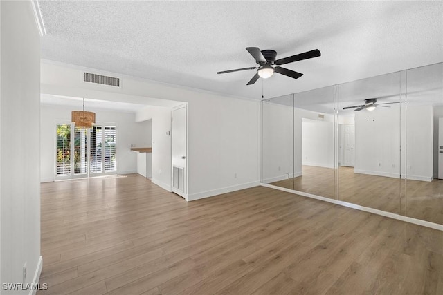 unfurnished bedroom featuring ceiling fan, wood-type flooring, and a textured ceiling