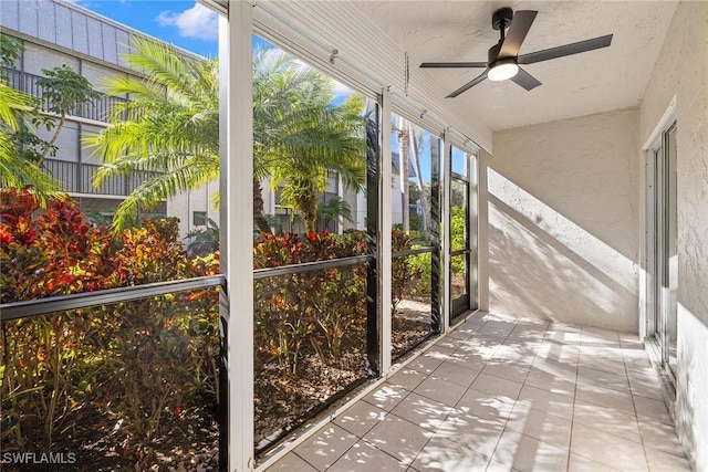 unfurnished sunroom with ceiling fan