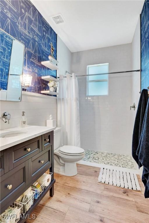 bathroom featuring a shower with shower curtain, vanity, toilet, and hardwood / wood-style floors