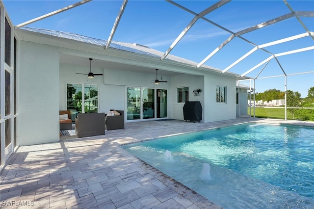 view of swimming pool featuring a patio, glass enclosure, ceiling fan, and grilling area